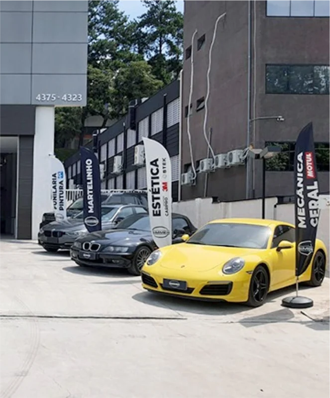 Wind Flag Banners em estacionamento de loja de carros de luxo